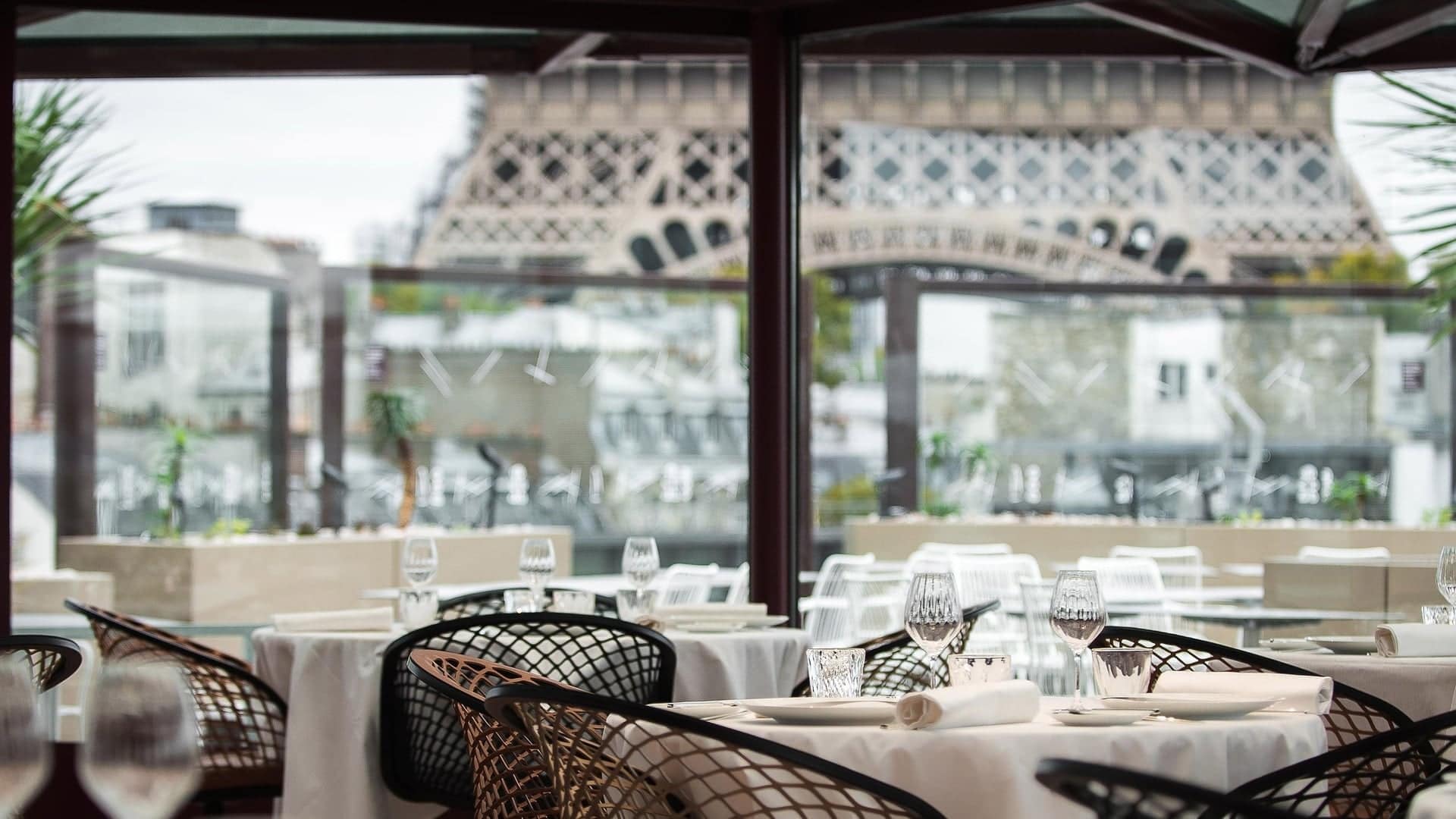 Dining area at Les Ombres with holey chairs, white tables and right next to the Eiffel Tower.