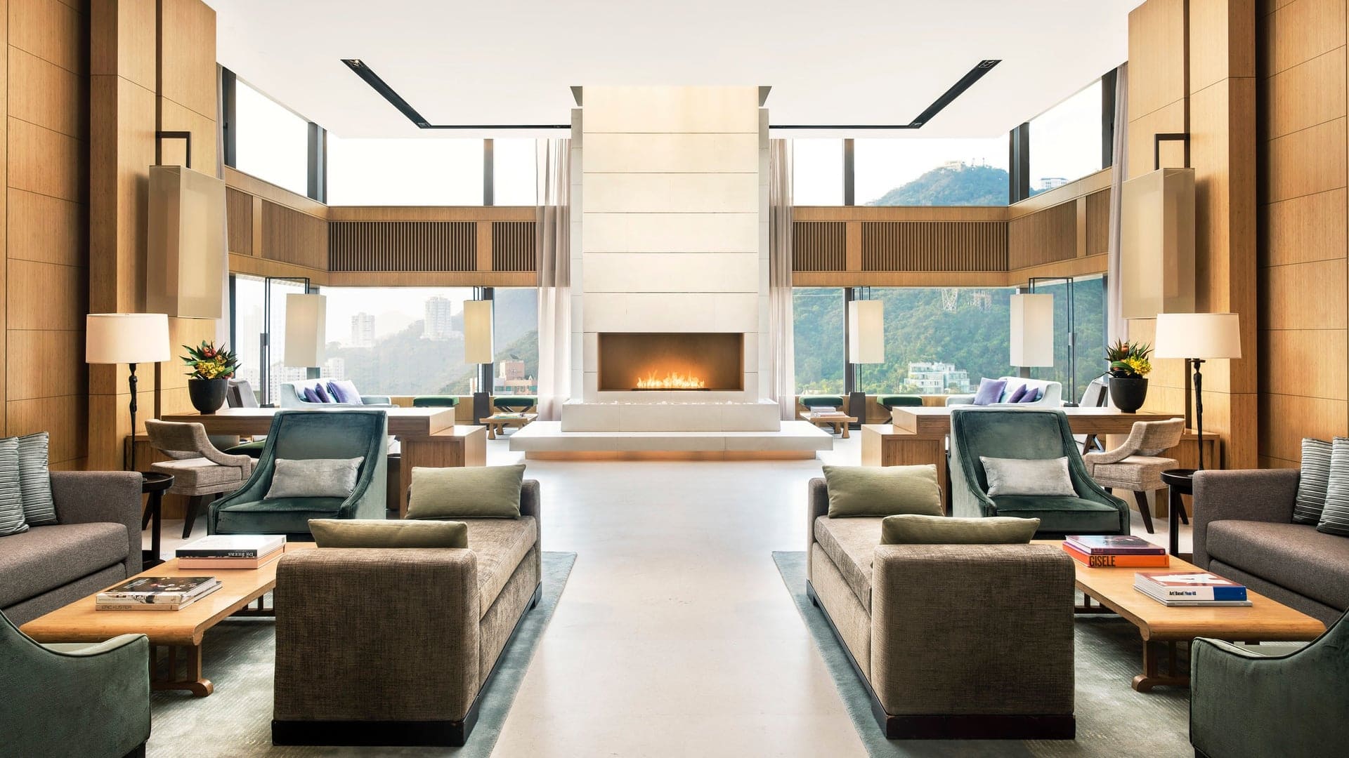 Suite at The Upper House with two seating area with sofas and chairs, large windows and fireplace.