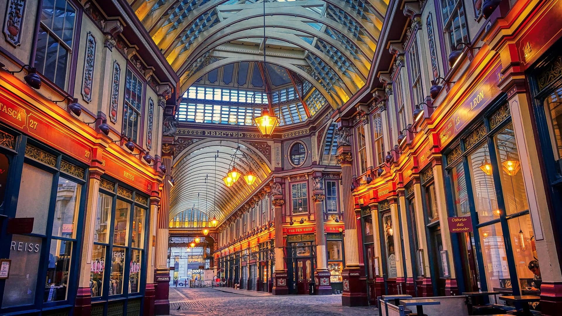 A beautiful corridor with large floor to ceiling space, classical and oldschool inspired shops and design with a tender lighting and stone floor.