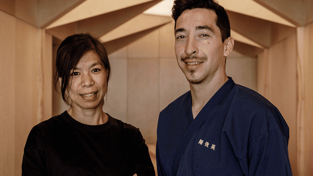 A man and a woman smiling at sushi shunei paris