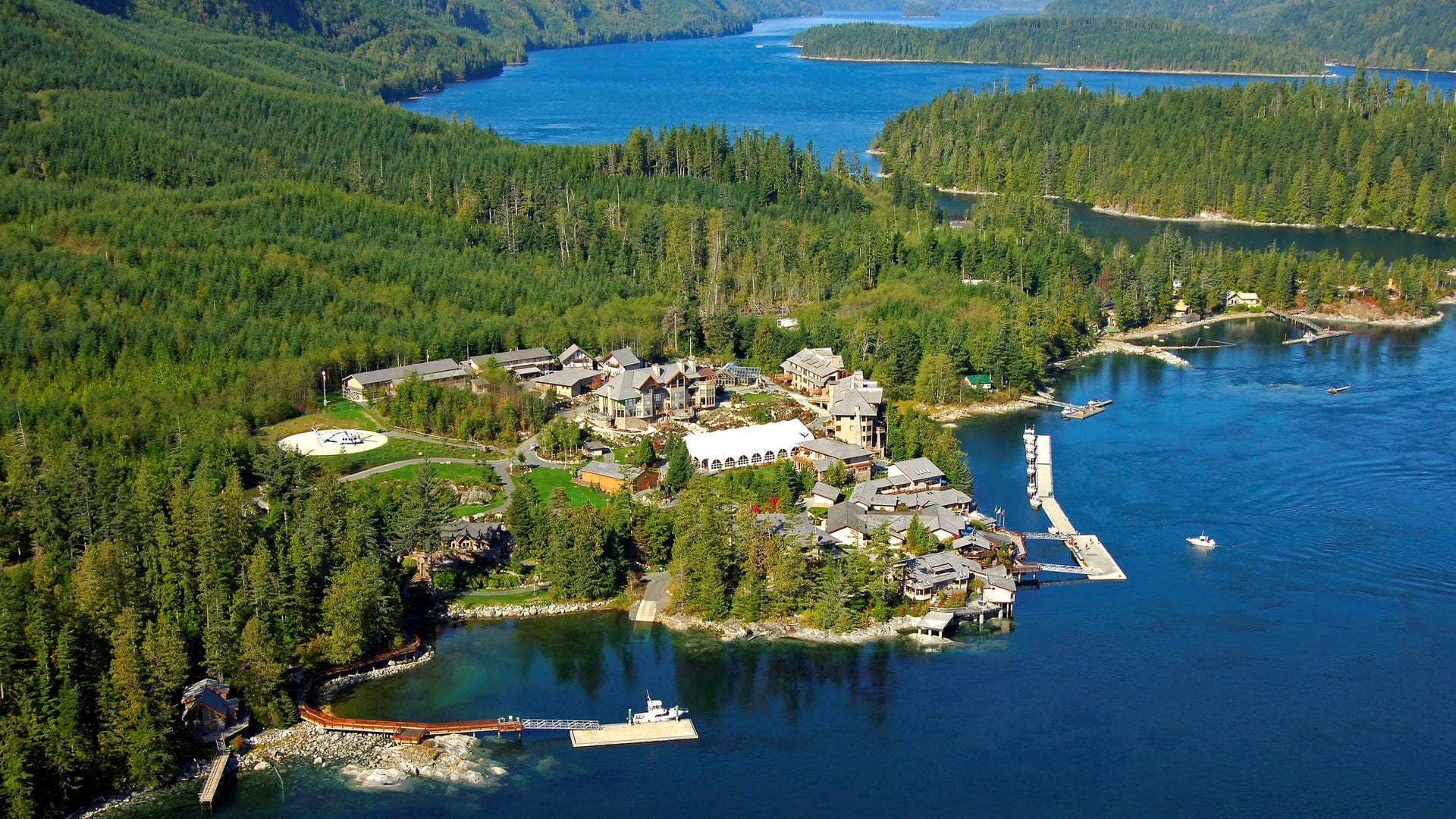 Bird view of Sonora Resort sorrounded by the woods and a beautiful river. The resort has multiple house facilities and a bridge at the water