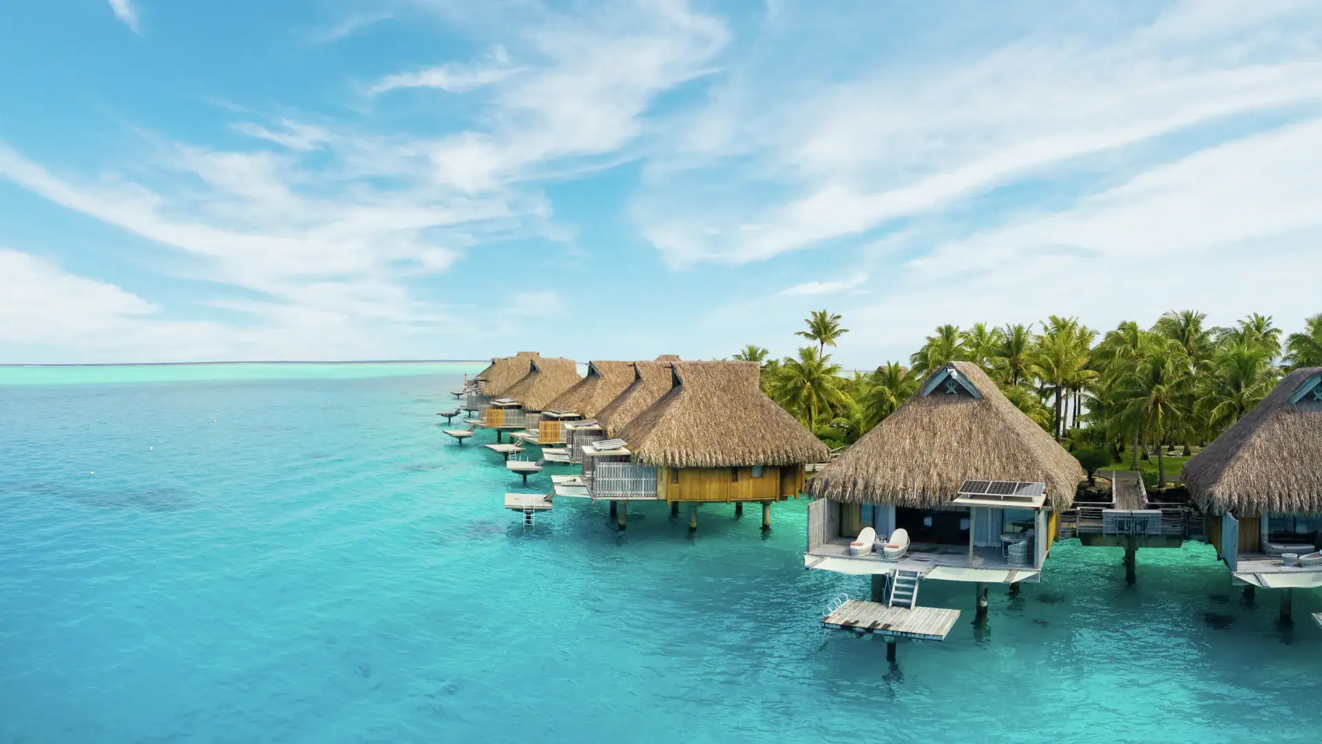 Wood cabins, clear water, palm trees and clear water in Conrad Bora Bora Nui.
