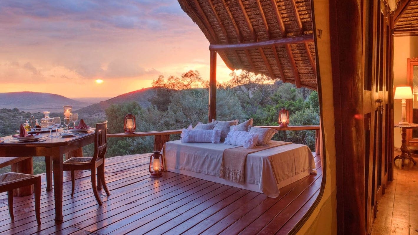 Terrace with tender lightning, white sofa and dinner table with a amazing view to nature and sunset