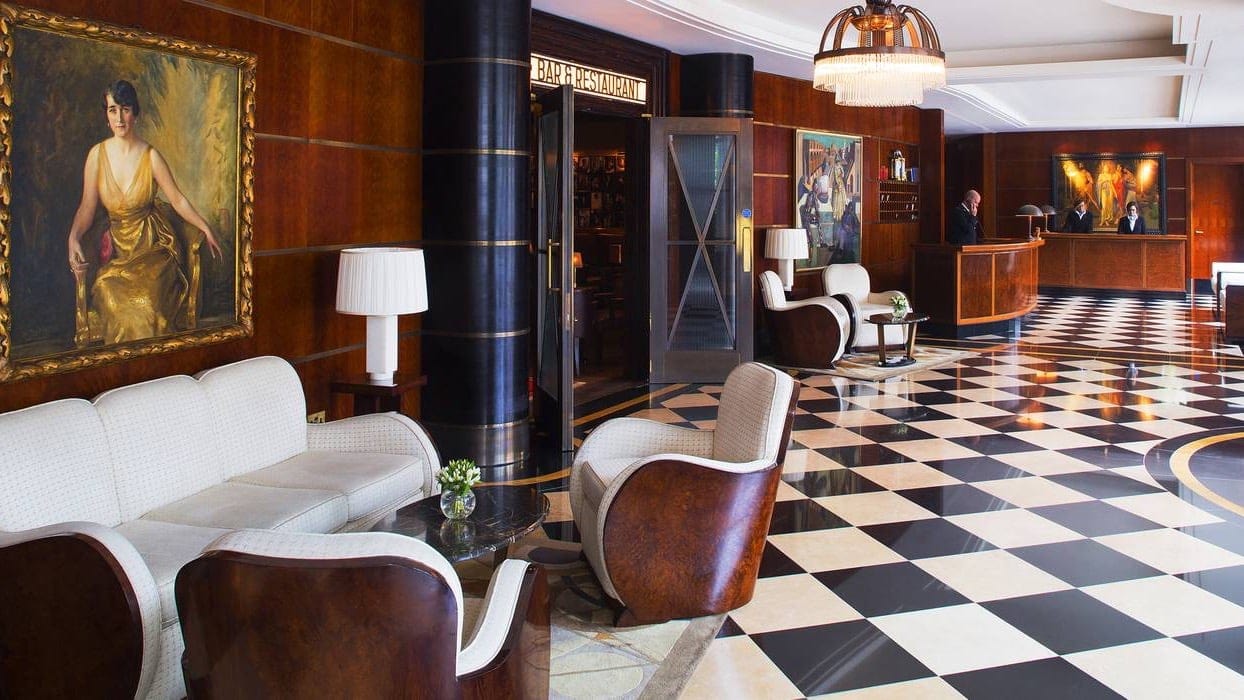 Reception at the beaumont london with brown walls and white and black squared floors.