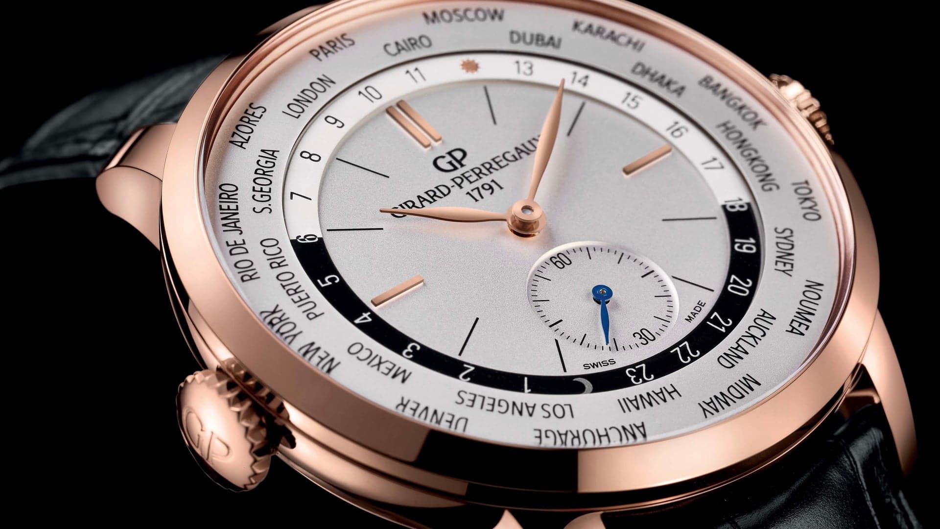 Girard-Perregaux travel watch with black background and bronze case.