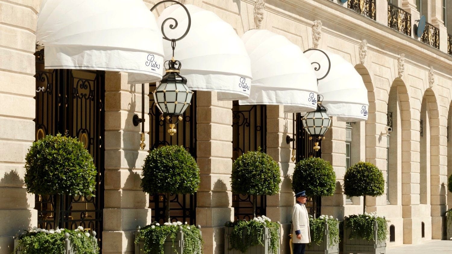 Main entrance of hotel ritz, paris with a doorman dressed in white outside