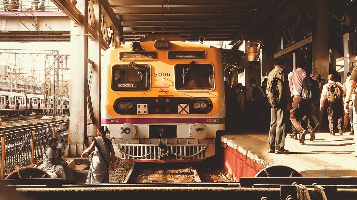 Train station in mumbai, a lot of people and a yellow train.