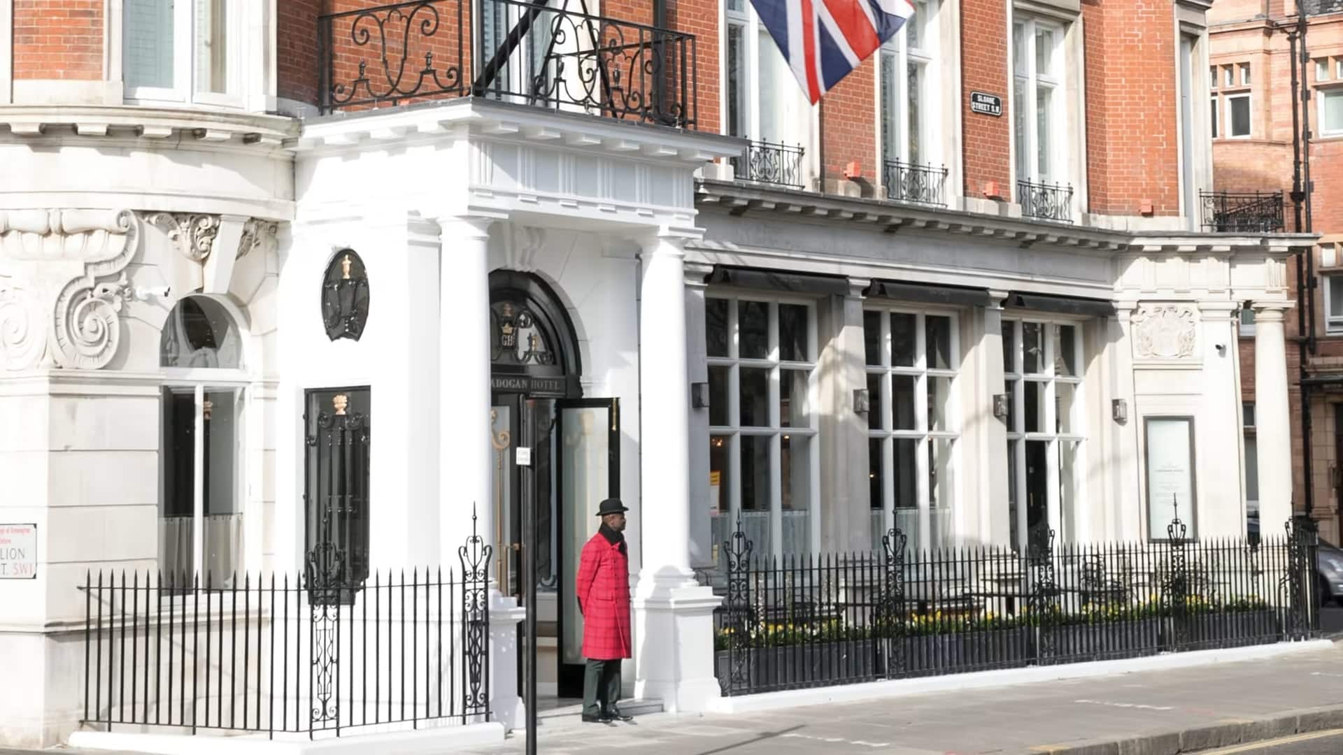 front entrance of Belmond Cadogan Hotel, London with a doorman in a red coat infront