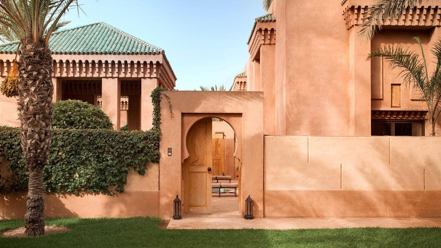 The outside of Amaniena is pastel orange with palm trees 