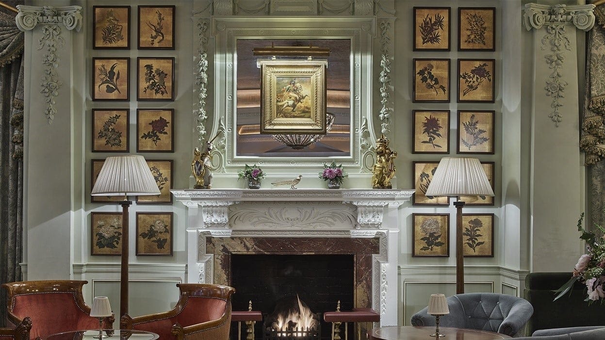 The goring bar at the goring hotel london with a fireplace and many paintings.