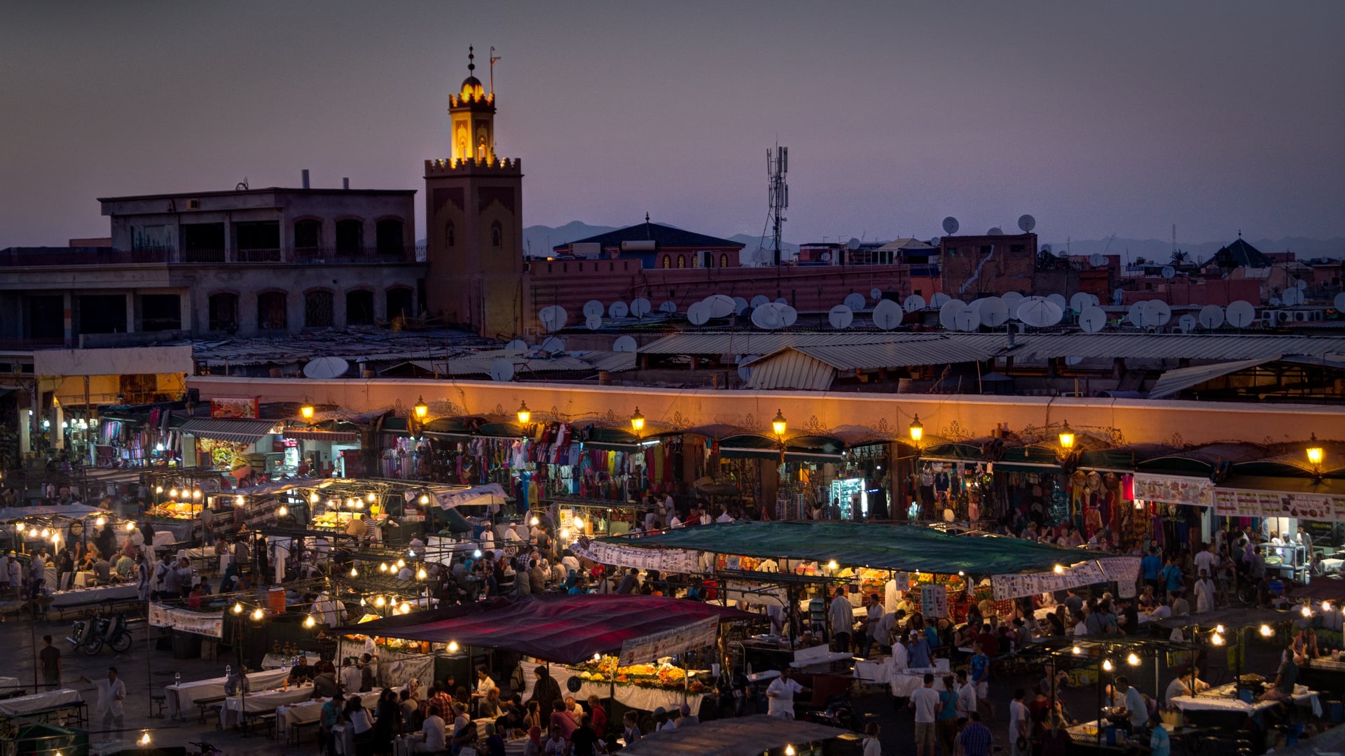 moroccan market and seat tables with many people sitting.