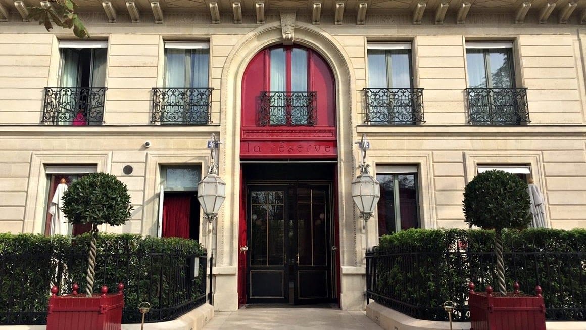 Main entrance of The la reserve paris hotel & spa with a black door 