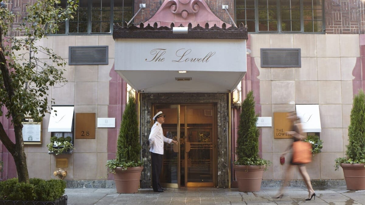 Main entrance of The Lowell Hotel new york with a doorman in white holding the door