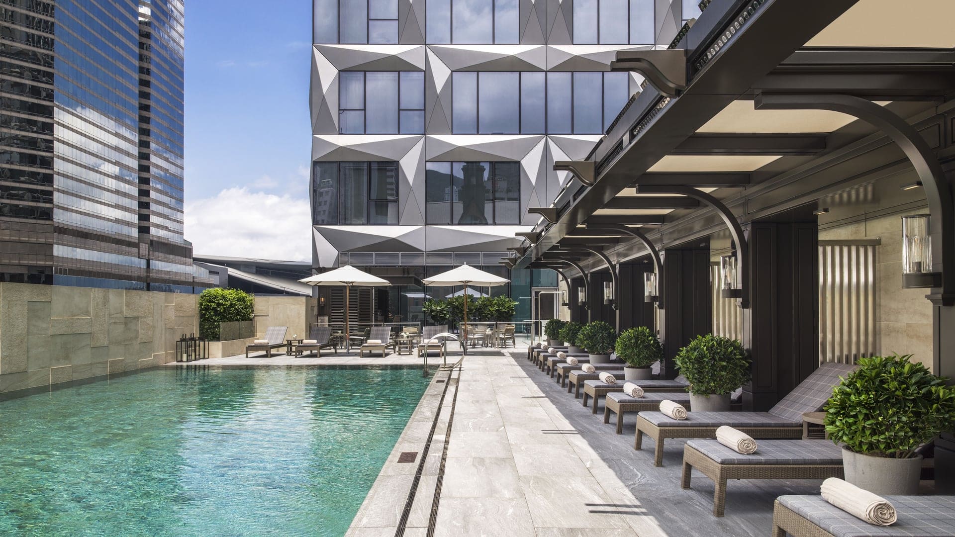 Pool area at The St Regis with multiple sunbeds, and futuristic design.