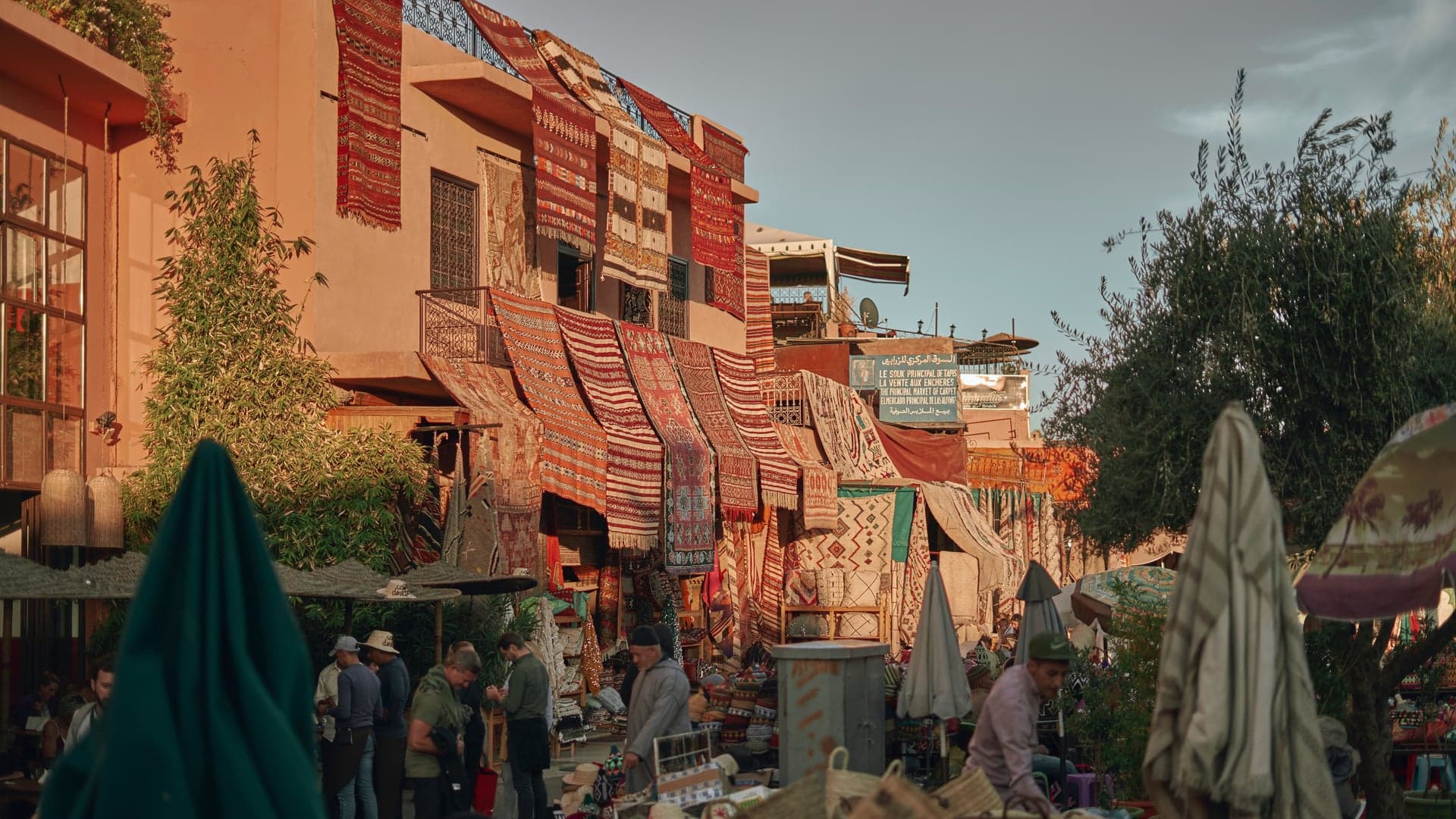 A moroccan market selling moroccan rugs hanging from the walls.