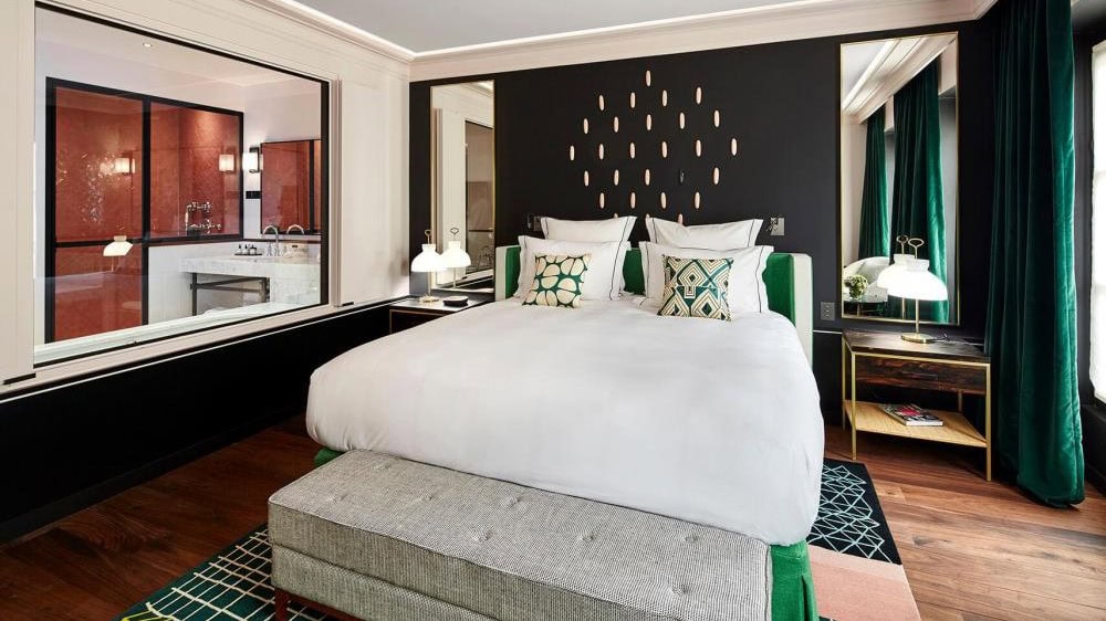 Room at Le roch hotel & spa with king sized bed and green curtains.