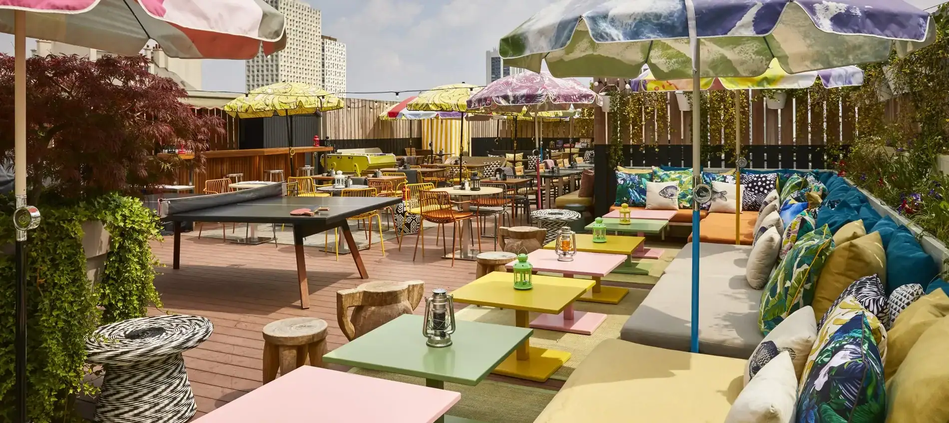 Colourful blast of furniture, table tennis, and wooden floor at Mama Shelter Paris East Rooftop.