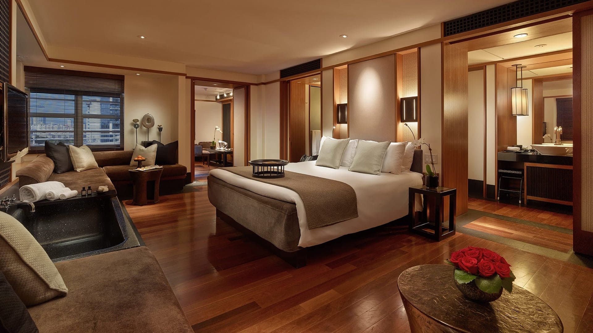 Exclusive suite at The iconic Setai, Miami Beach with kingsize bed, couches and multiple rooms with warm colours and a wooden style interior