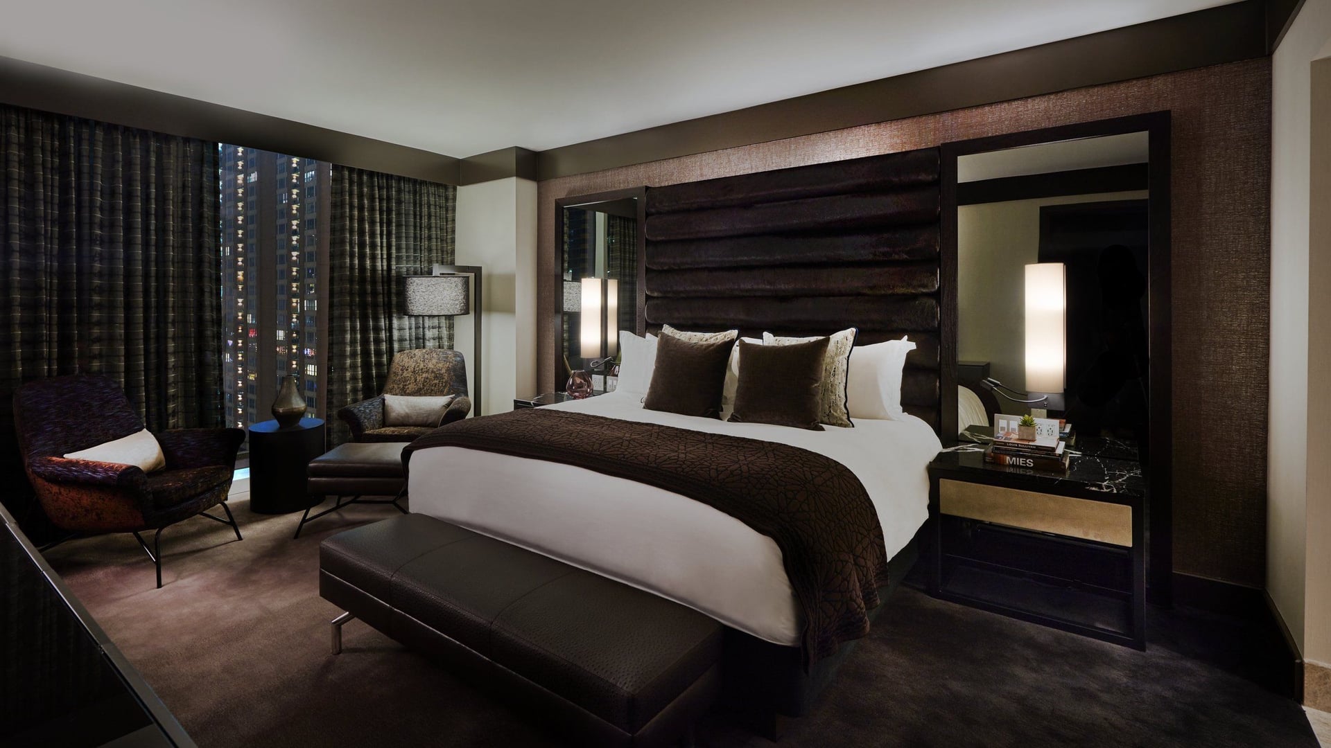 Suite at Loews with dark colours and view of the city at night time