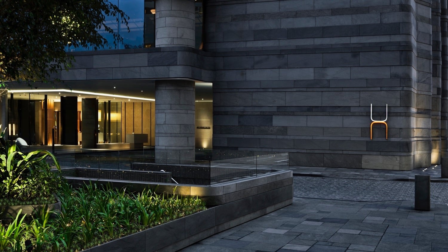 Grey, futuristic design of the outside of The Upper House in Hong Kong with pool and nature garden.