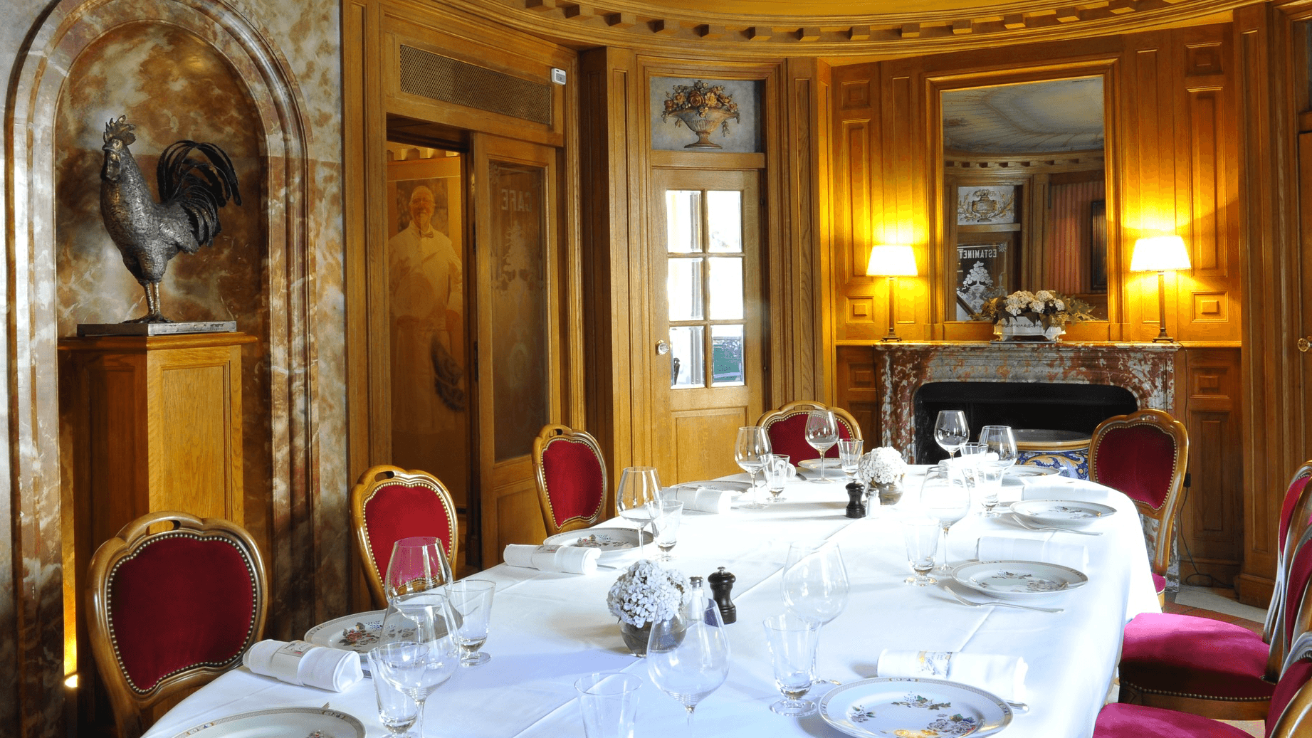 A table with red chairs and gold walls at resturant benoit paris