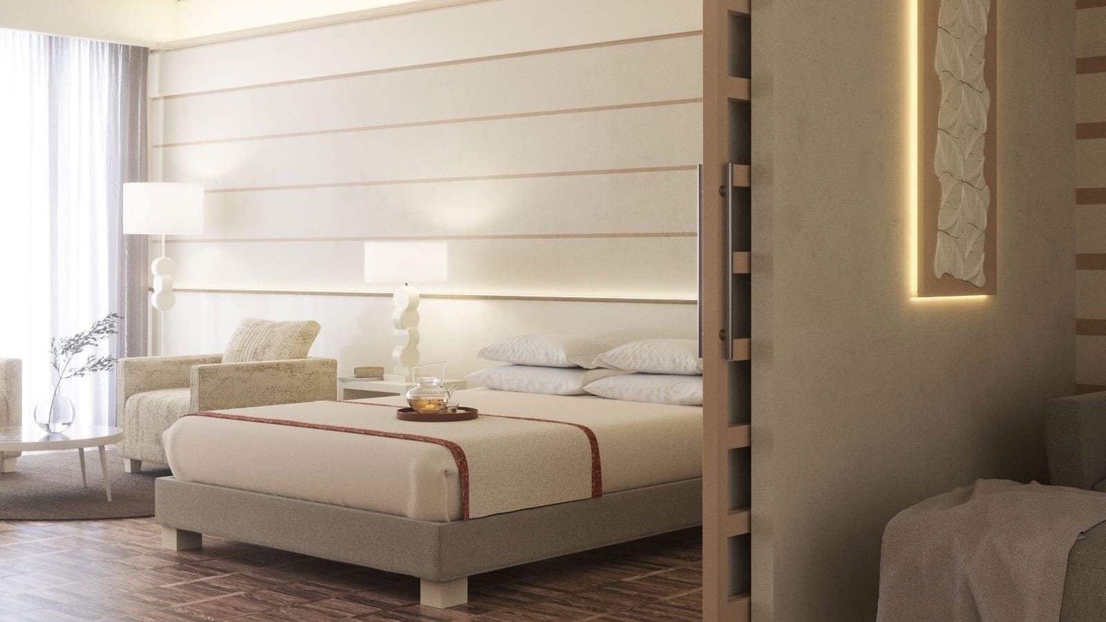 A spa room with a big double bed, two chairs on the right and two lamps.