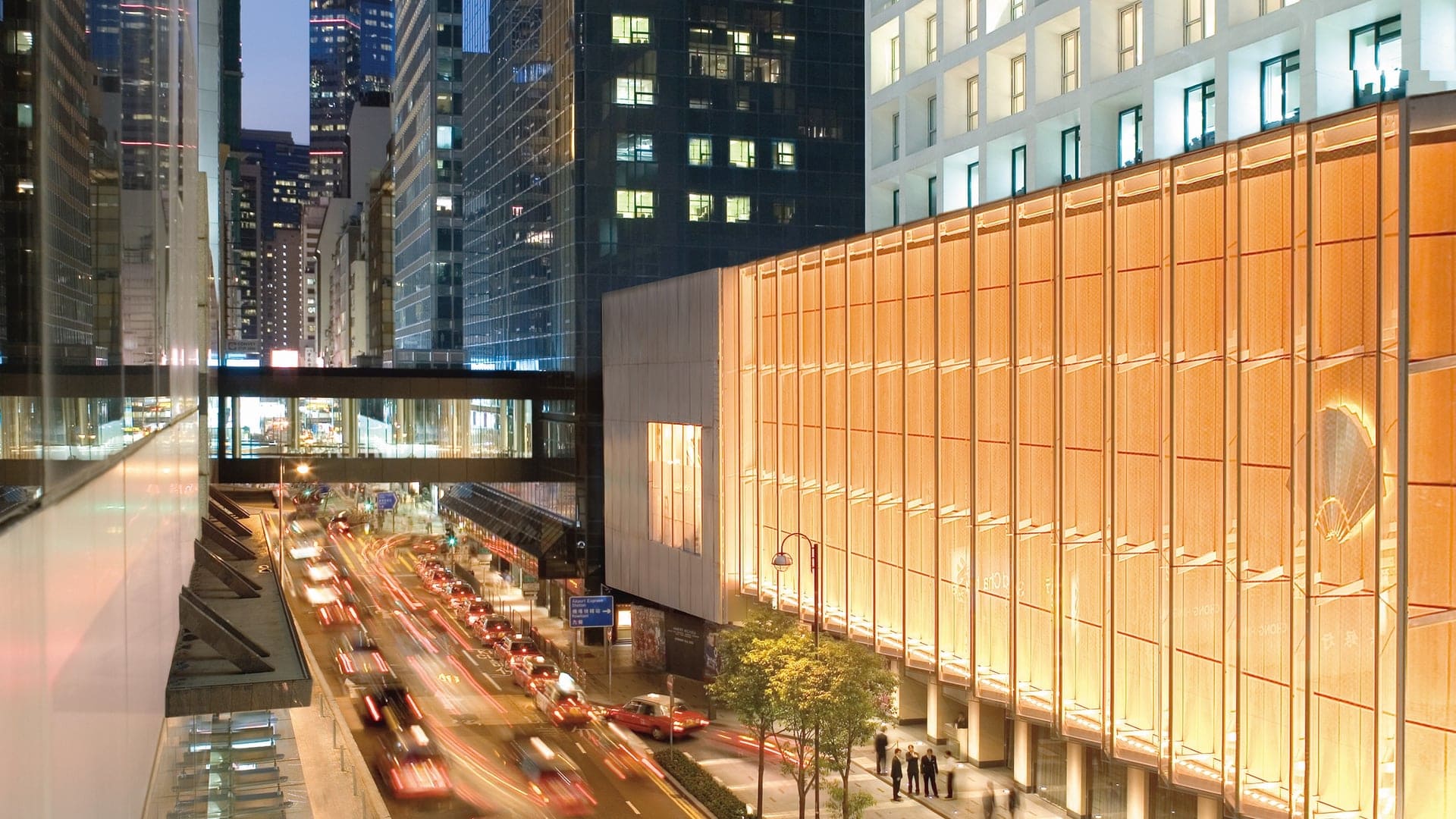 Outside view of Mandarin Oriental, busy street of Hong Kong and the Mandarin Oriental building with it's iconic logo.