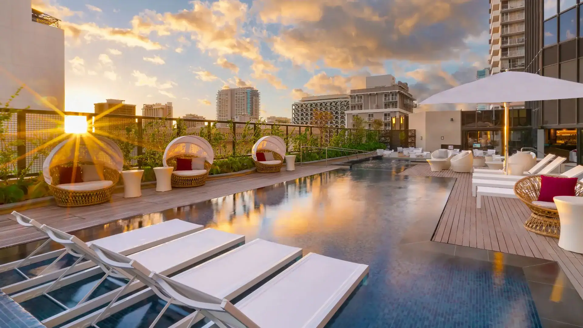 Pool area with sunbeds and chairs at Hyatt Centric Waikiki Beach.