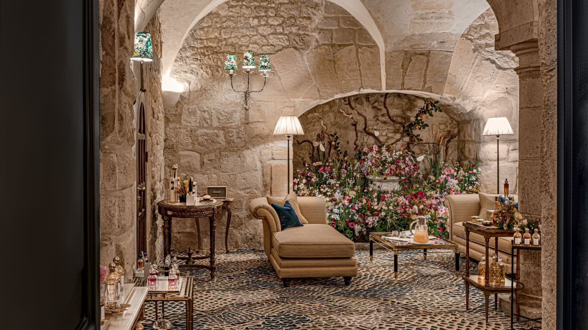 Room at relais Christine paris with brick walls, chairs, table and flowers 