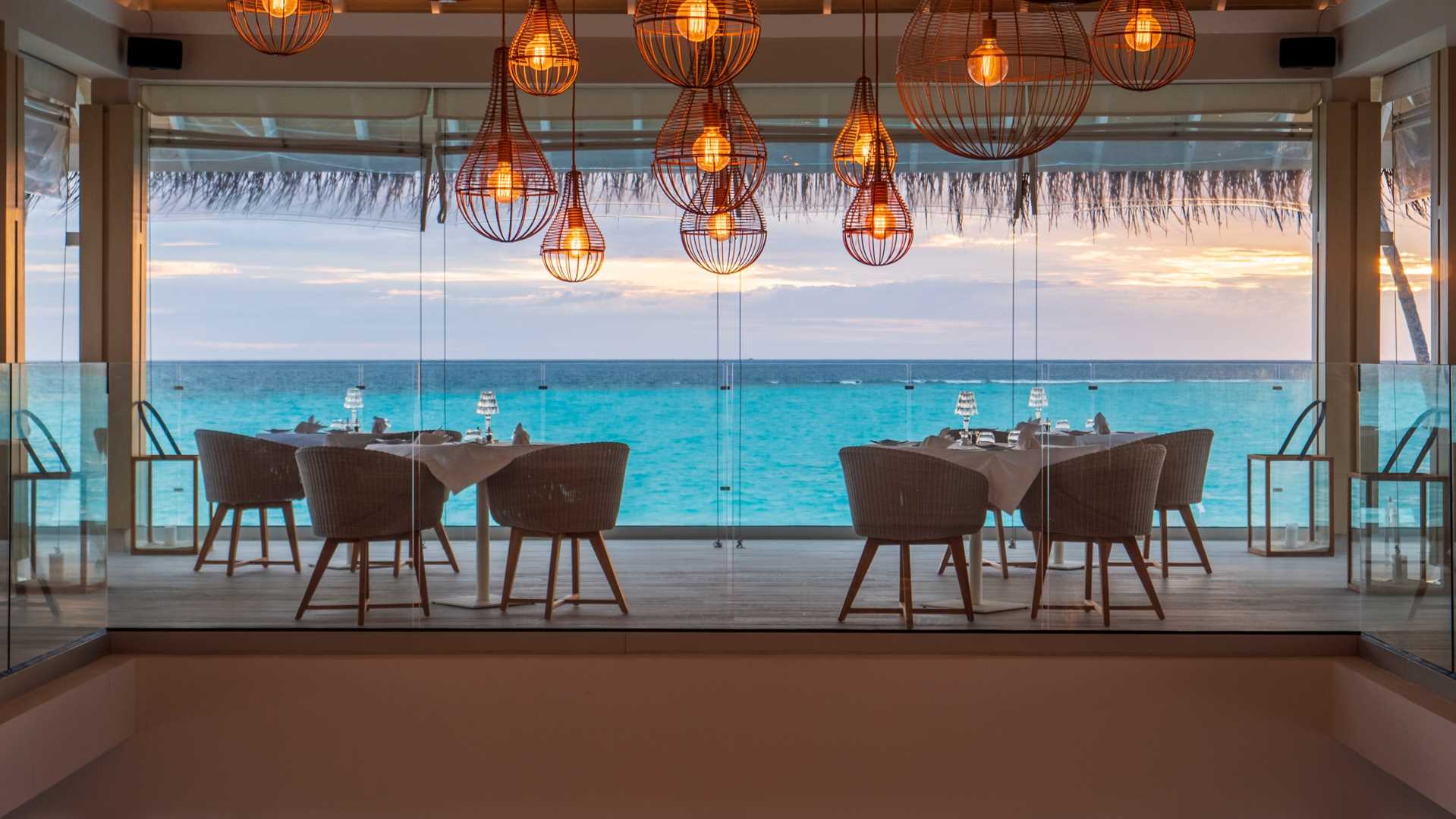 Dining area with large windows view to the ocean at Baglioni Resort Maldives.