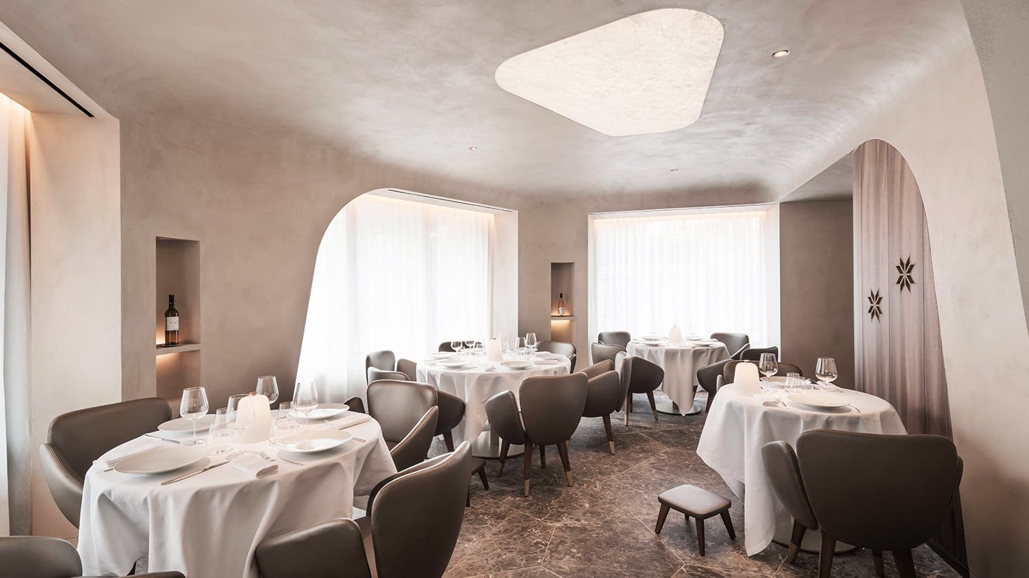 Mavrommatis Le Restaurant with grey chairs and round tables