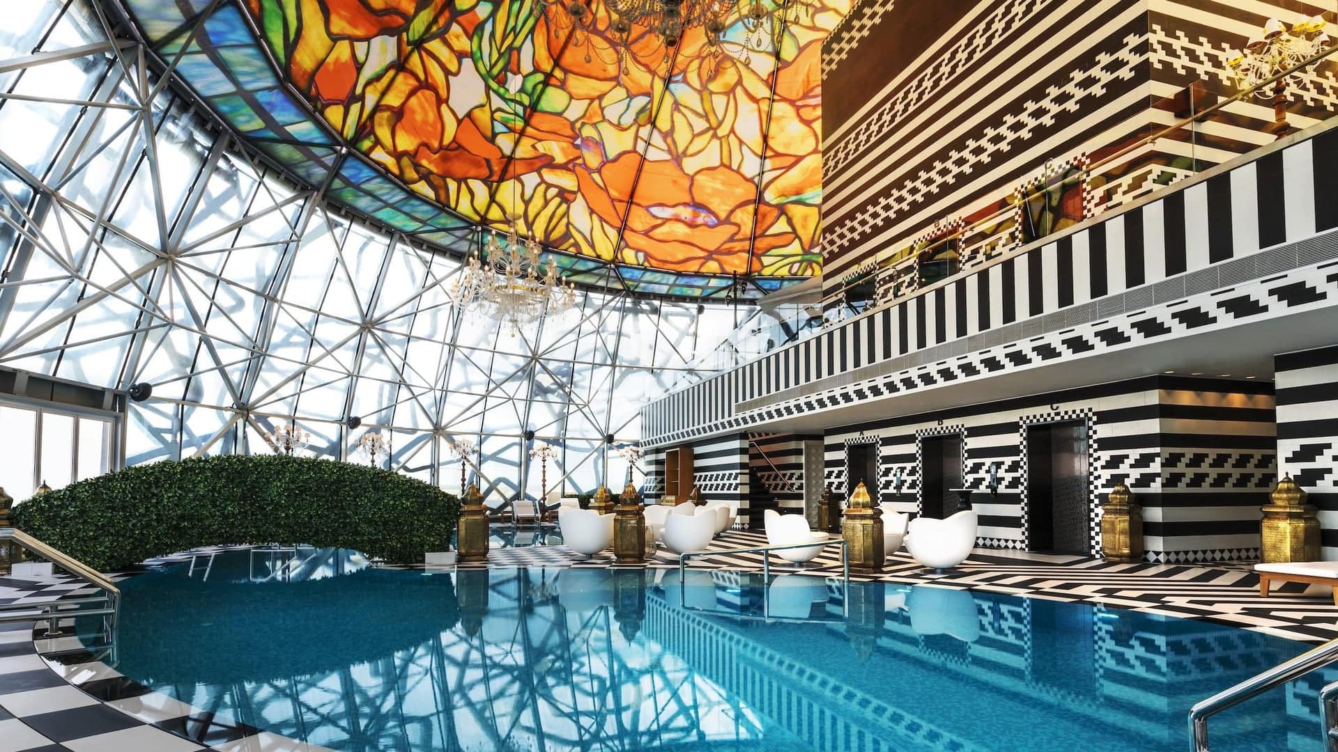 Indoor pool area, with cool design and a glass bowl as roof.