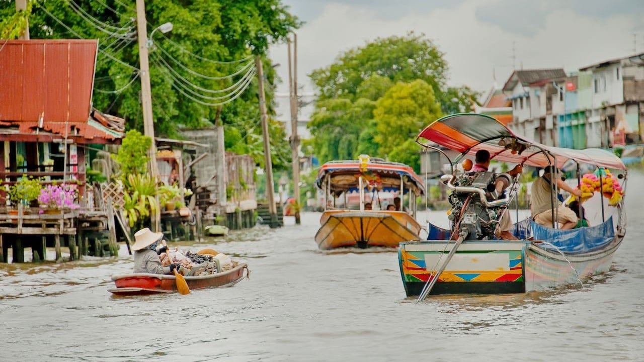 people driving boats and paddling atThonburi