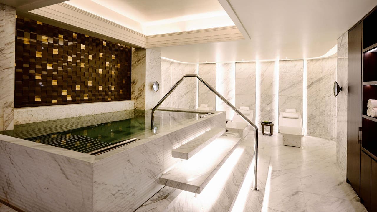Large bathtub area with spa beds and white marble.