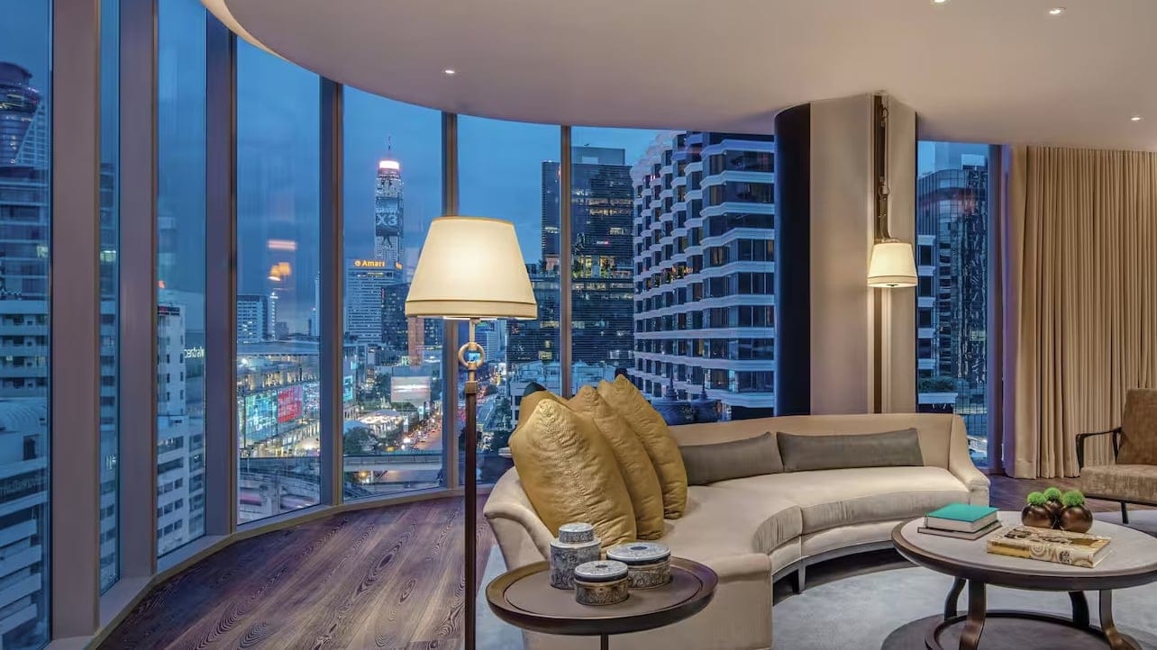 Living room with big windows overlooking the city at waldorf astoria bangkok