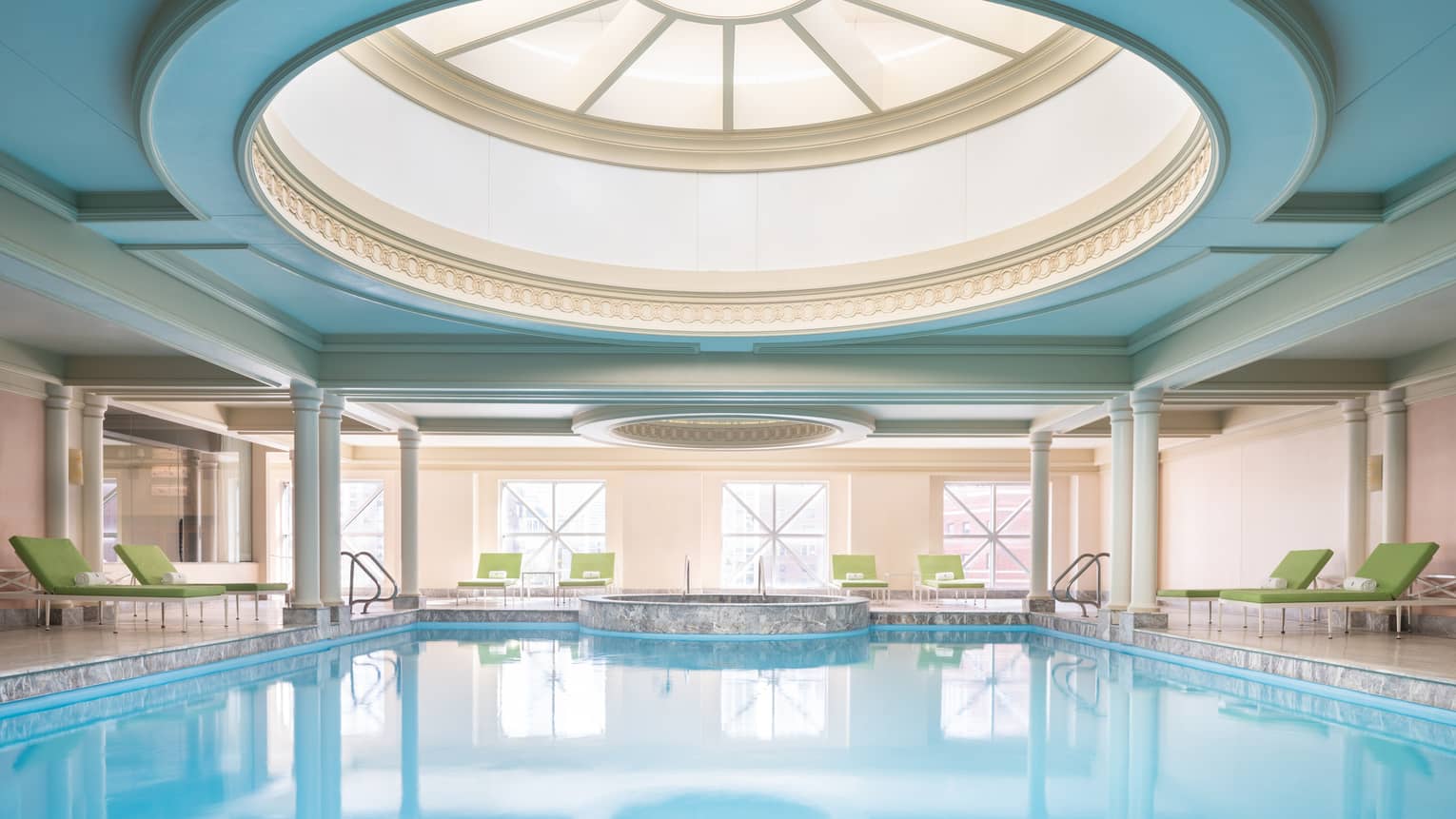Inside pool at Four Seasons Hotel in Chicago with green sunbeds