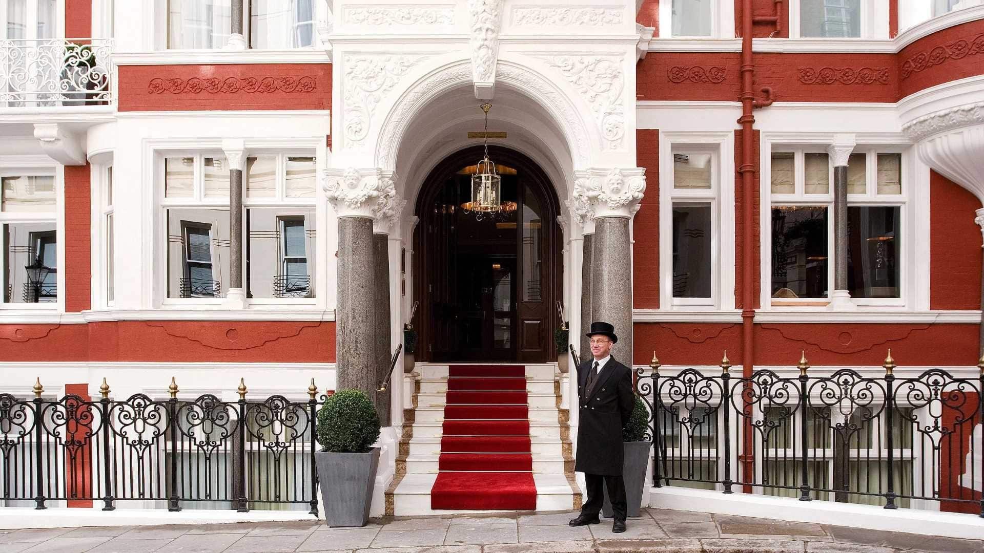 Front entrance of St james´s Hotel & club mayfair london with a doorman dressed in black infront.