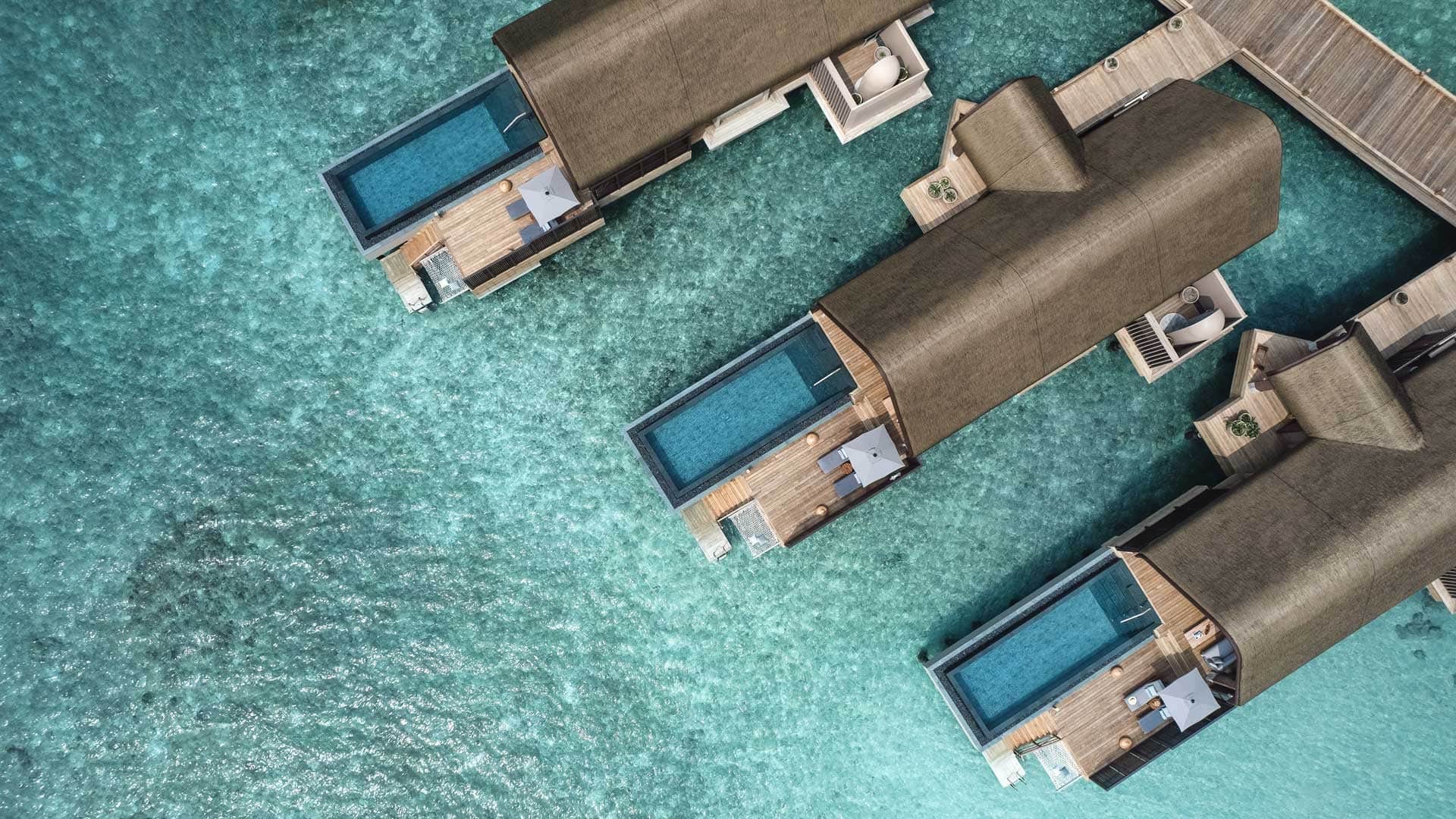 Bird view of three suites on the water all with pools, sunbeds, and entrance to the suite in JOALI BEING.